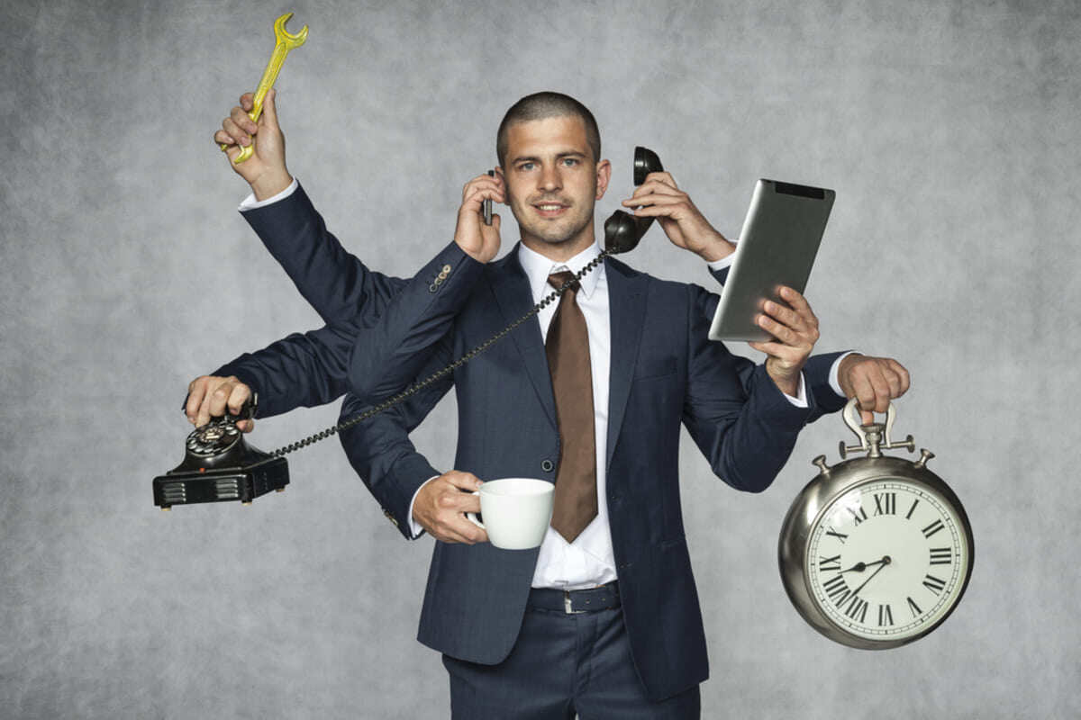 A businessman with multiple arms holding different objects
