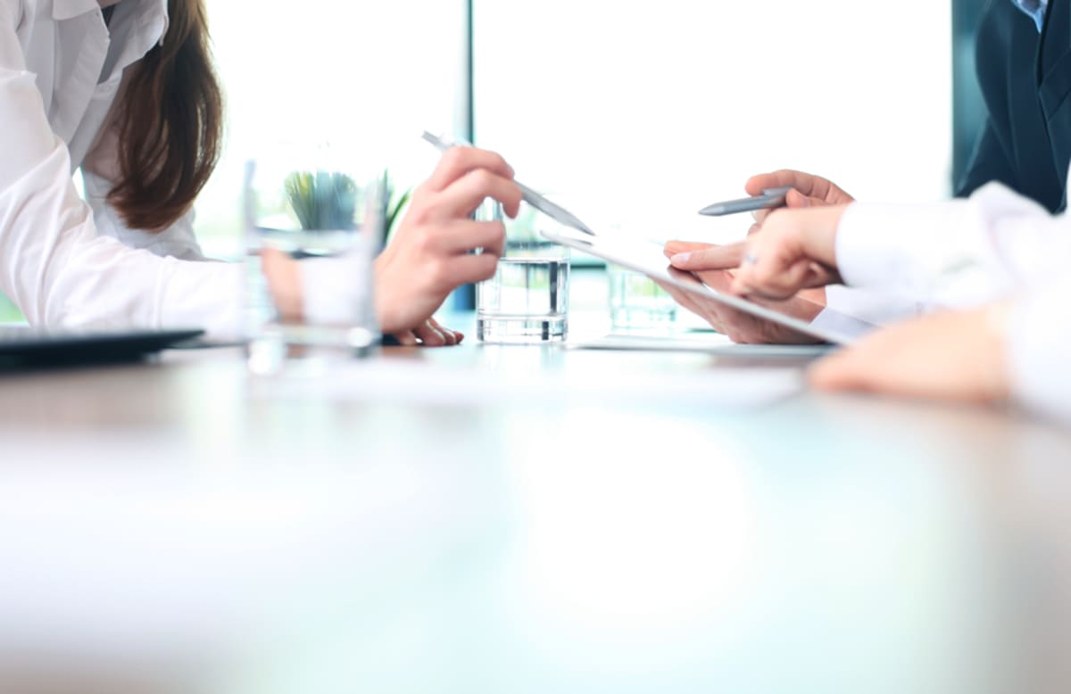 Close-up of people meeting over a table, property management consultant concept