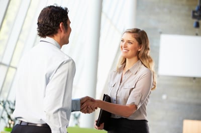 A businessman and businesswoman shaking hands