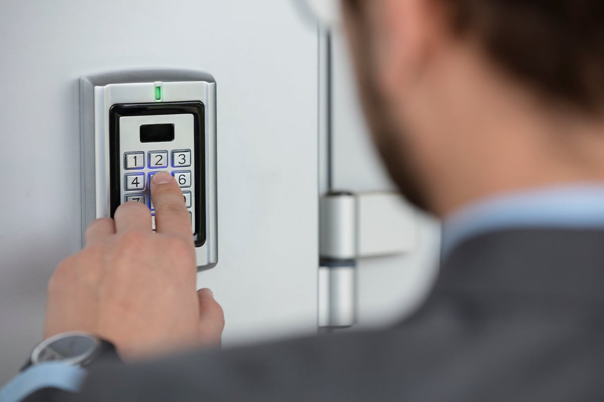 Close up of businessman hand entering security system code