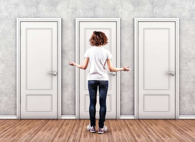 Lady standing in front of 3 doors choosing which one to open