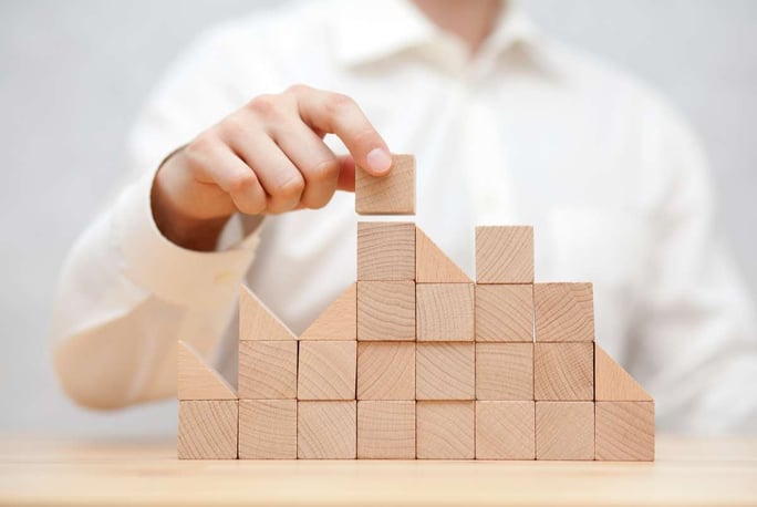 Mans hand stacking wooden blocks. Business development concept (R) (S)