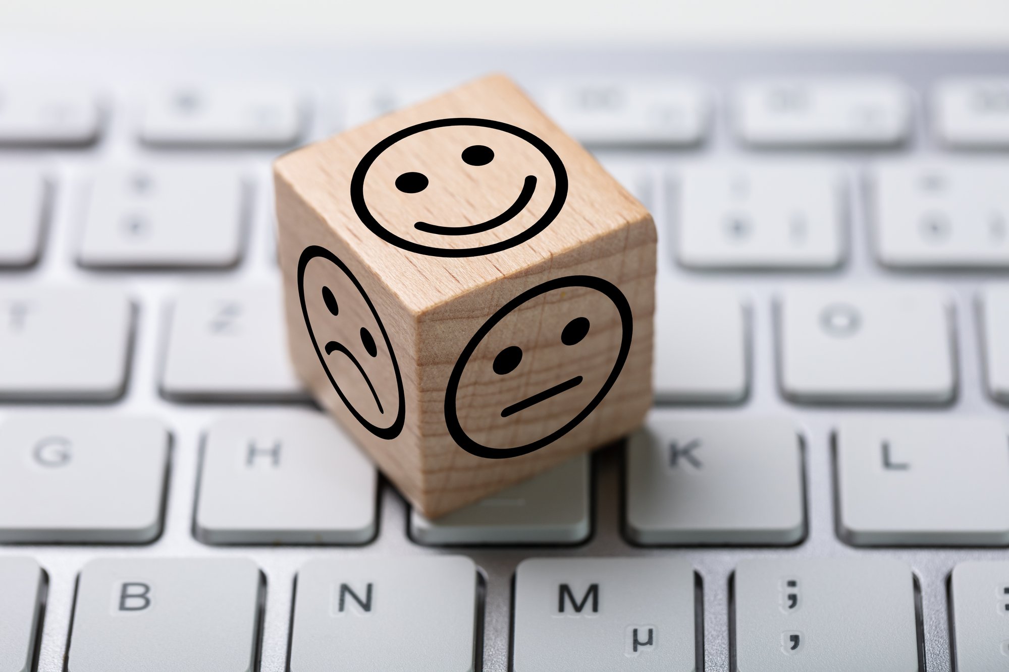 Happy and sad face on a wooden die on keyboard, improve property management business concept. 