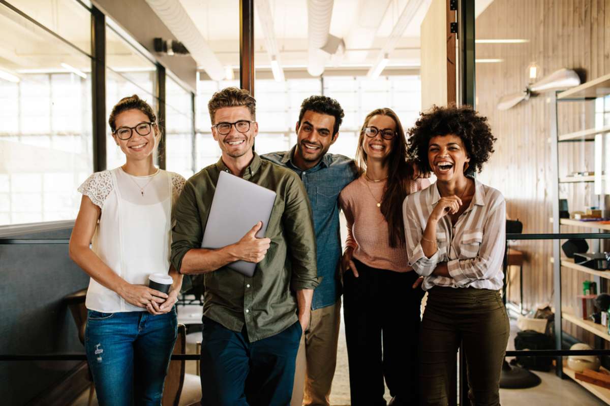 Portrait of creative business team standing together and laughing