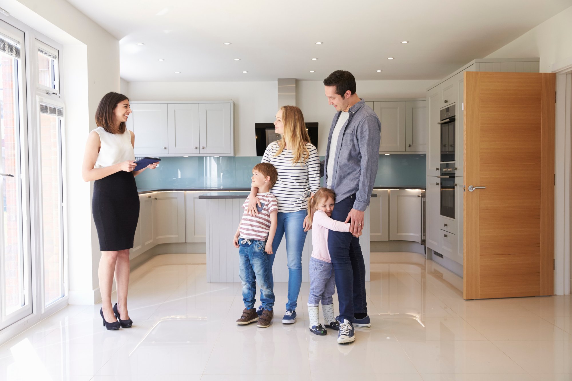 Realtor Showing Family Around Property For Sale