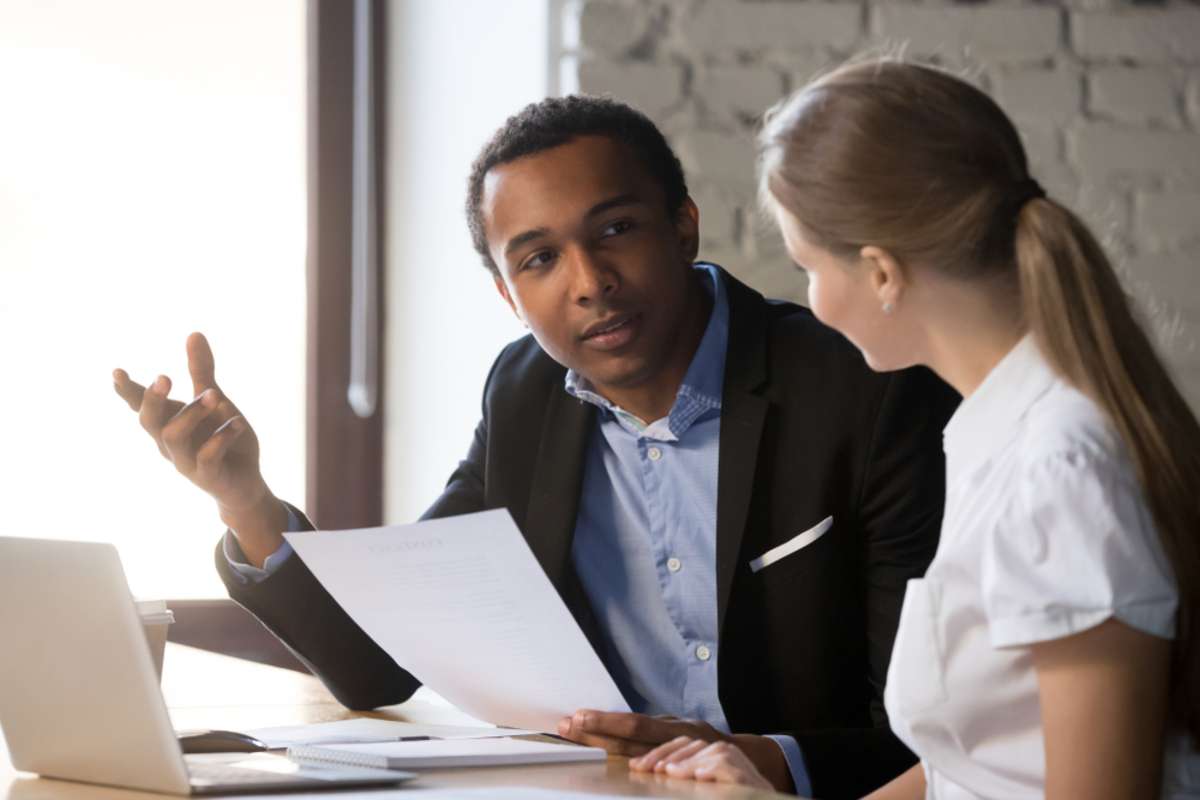 African american boss negotiating discussing contract details with company corporate woman client