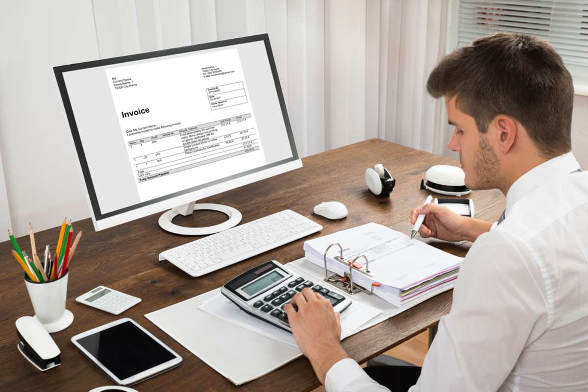 An accountant viewing an invoice helps improve property management operations