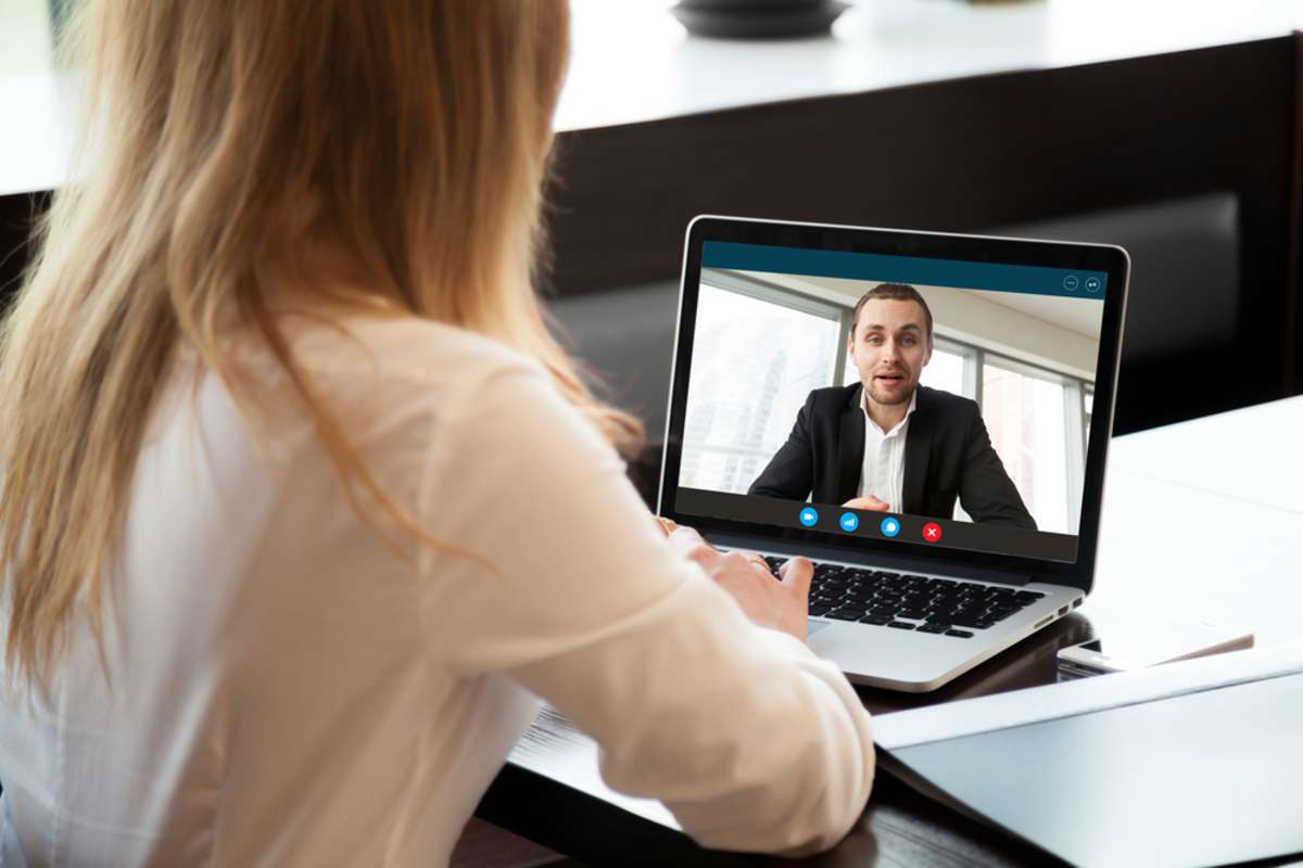 Businesswoman making video call to business partner using laptop