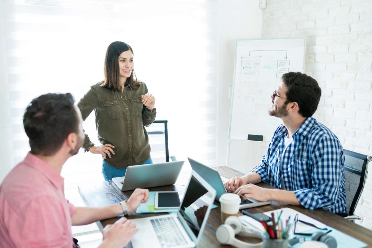 Female entrepreneur leading presentation to team in meeting room at office