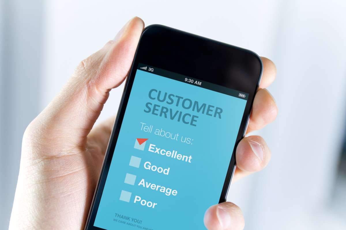 Mens hand holding modern mobile phone with customer service survey form on a screen