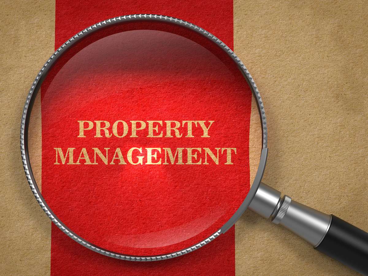 Property Management. Magnifying Glass on Old Paper