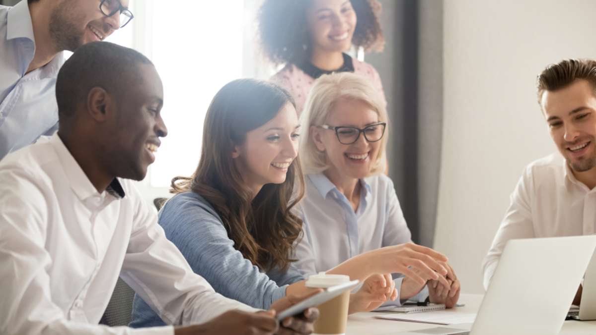 Smiling diverse employees listening to businesswoman coach at briefing