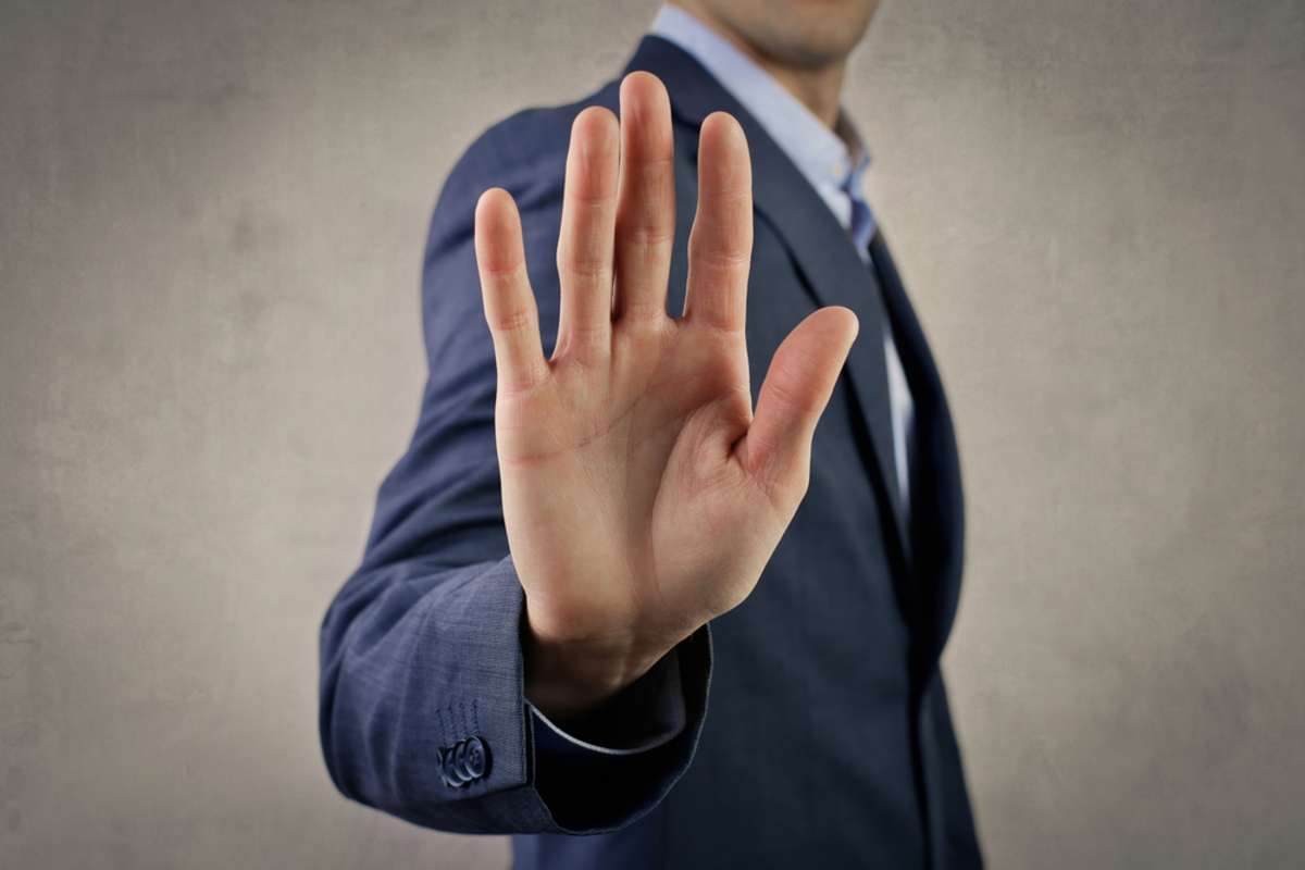 Man in a suit with hand doing the stop gesture