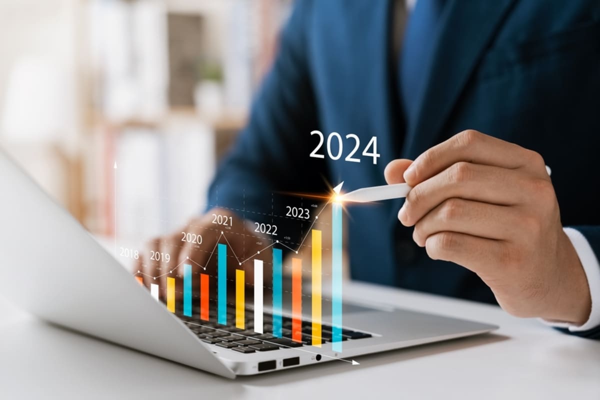 Someone pointing at a graph on a laptop