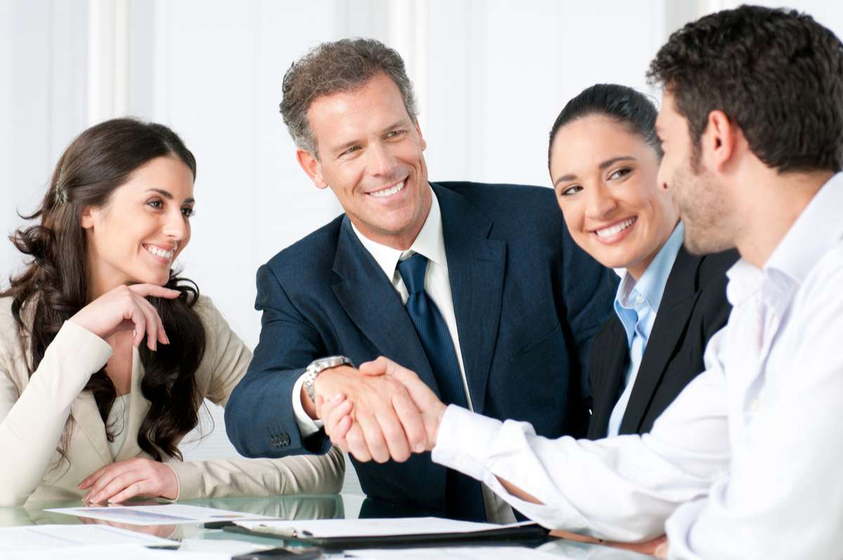 Team meeting where two among them are shaking hands