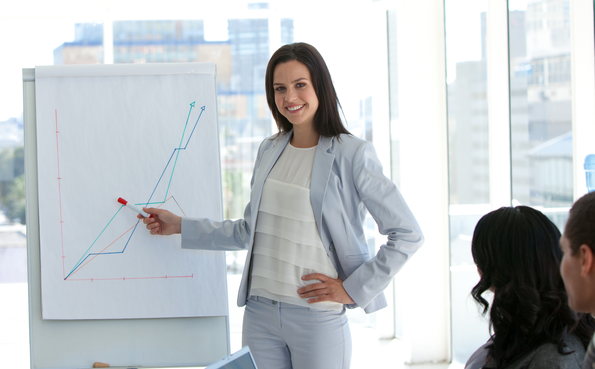 Lady in a suit discussing a graph 