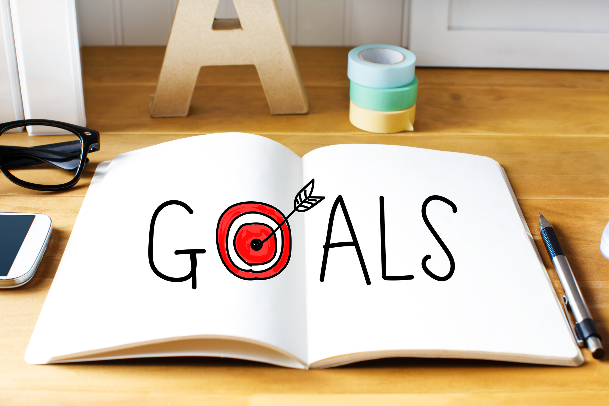 The word Goals written on an open notebook with a bullseye for the letter o