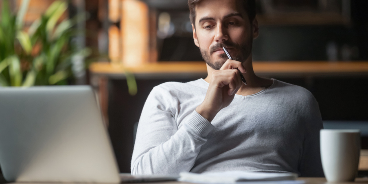 Pensive bearded man sitting at table