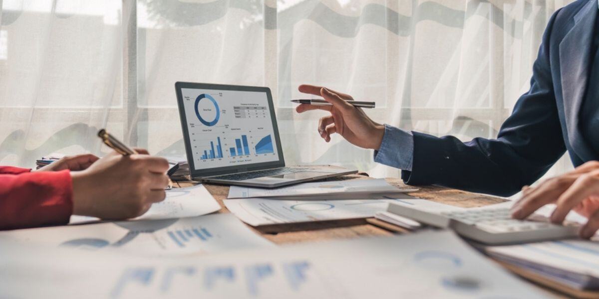 04 Businessman discuss project planning with colleague at modern workplace while having conversation and advice on financial data report