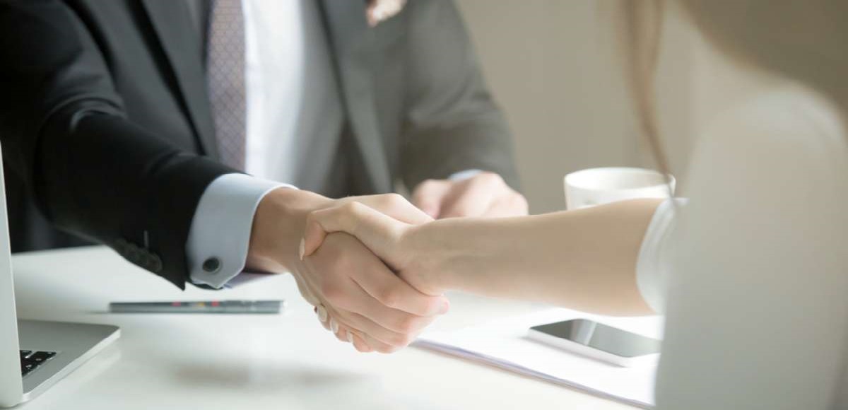 Closeup of male and female hands handshaking after effective negotiation showing mutual respect