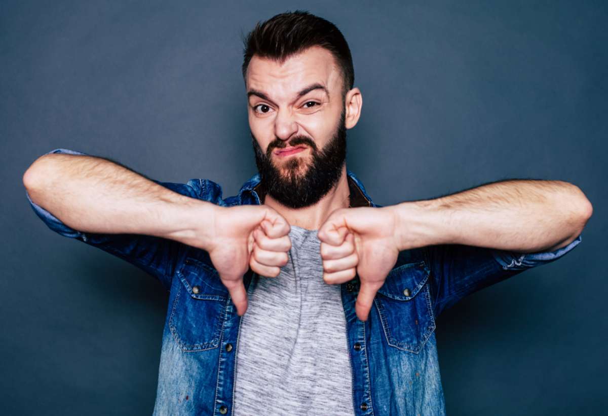 Man in casual clothing doing a thumbs down sign with both hands