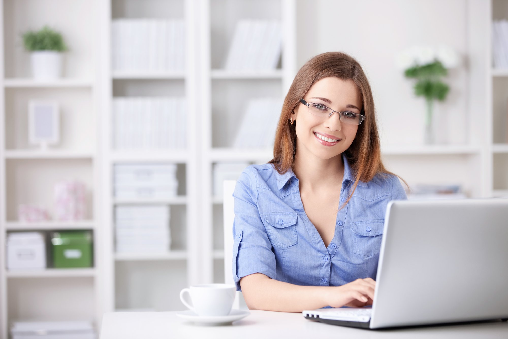 Smiling young lady working on her laptop
