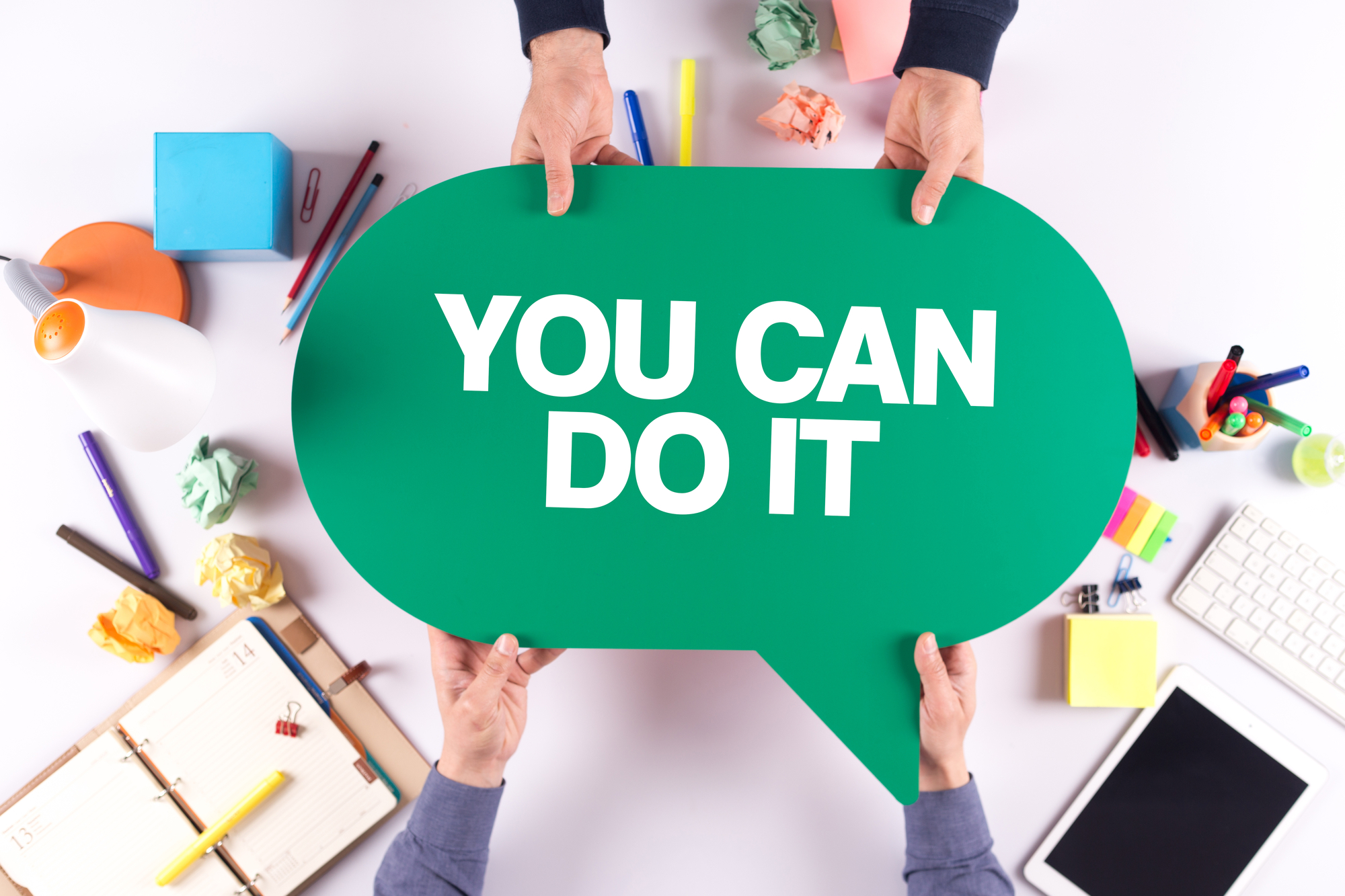 the words you can do it printed on paper being held by two people