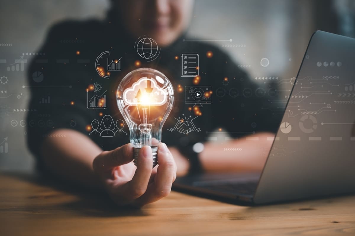 a woman holding a lightbulb that shows symbols for different business operations-1